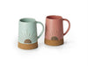Two ceramic mugs with cork bases on a white background