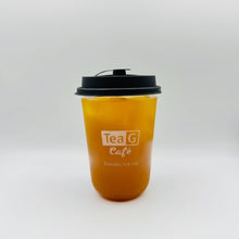 A clear plastic takeaway cup filled with amber-orange iced tea, topped with a black lid, and printed with the Tea G Cafe logo on a light gray background.